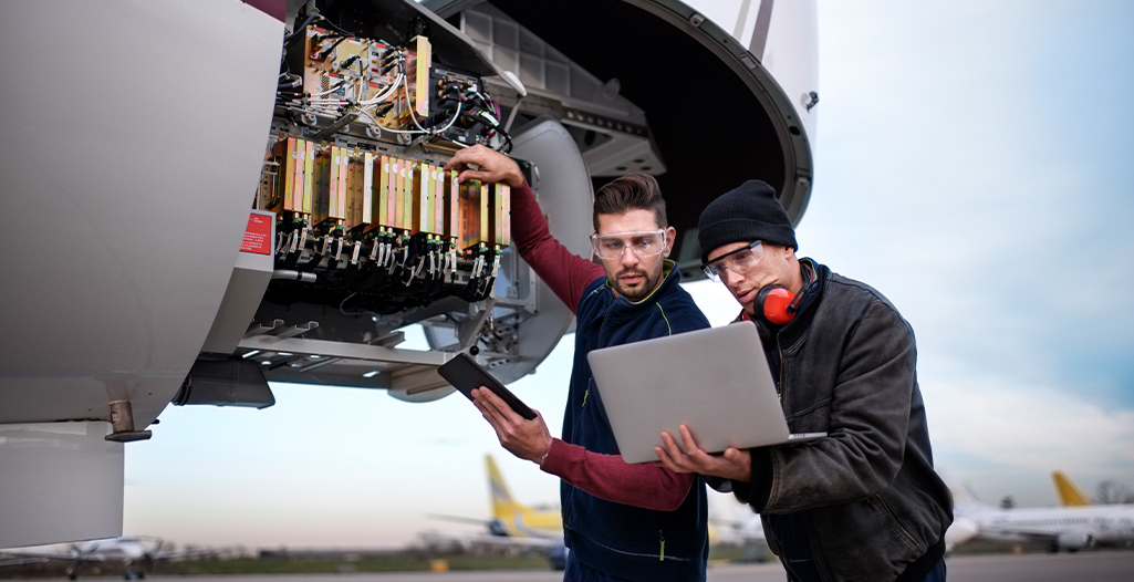 Aircraft engineers repairing and maintaining jet airplane.