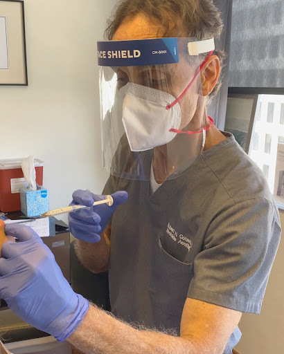 Dr Wearing a mask and gloves preparing a botox injection