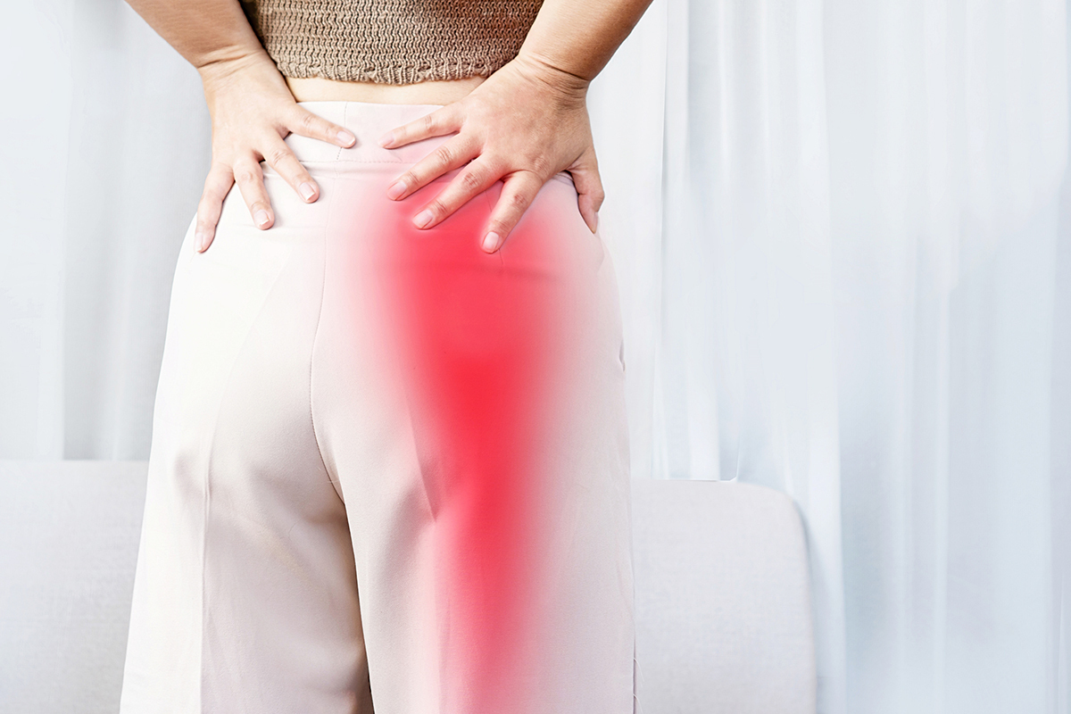 Sciatica Pain concept with woman suffering from pain spreading to down leg.