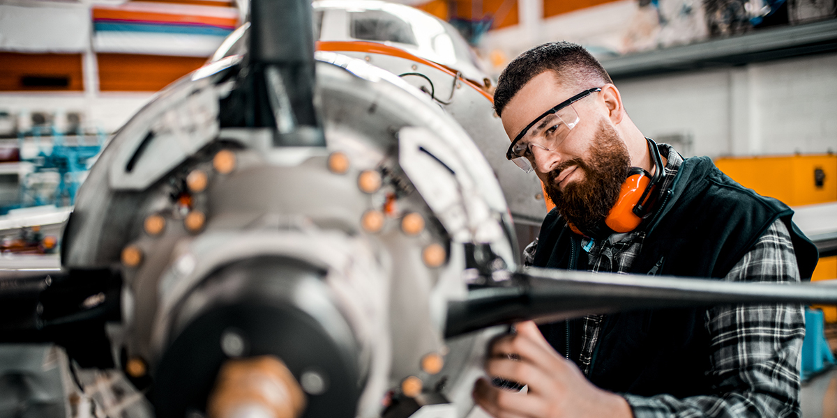 Technician working on airplane propeller