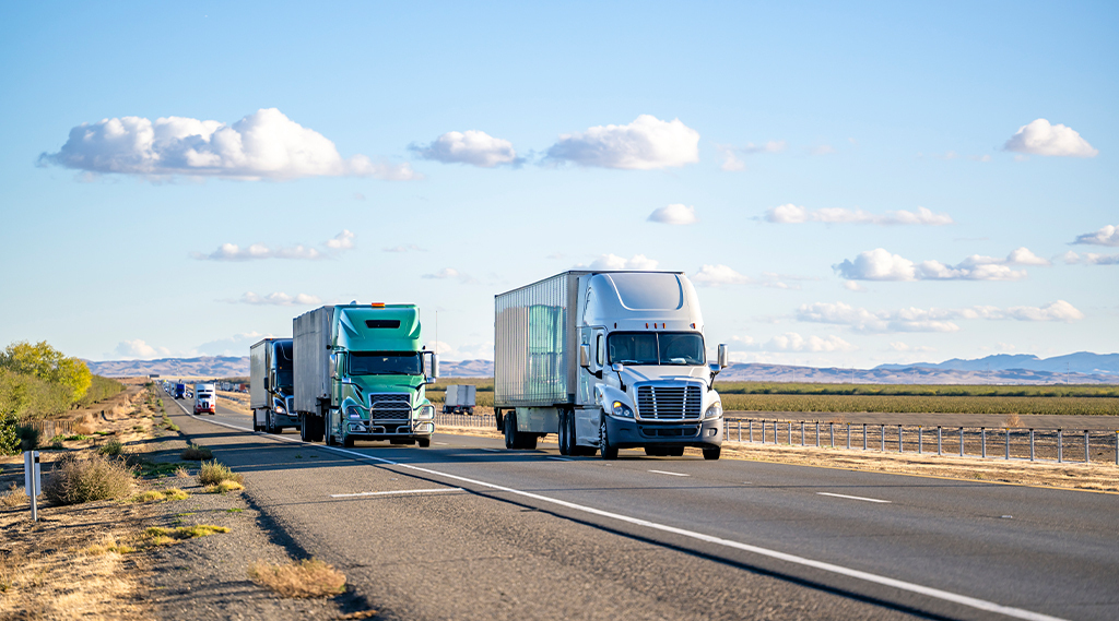 semi trucks carring cargo on divided highway