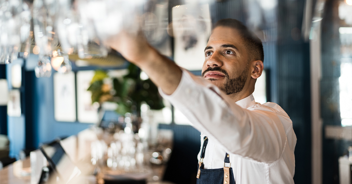 Bartender arranging glasses