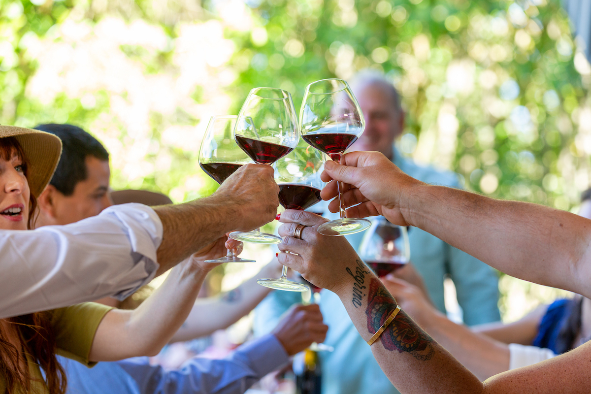 Visitors raise their wine glasses at a wine tasting experience at Halleck Vineyard in West Sonoma County