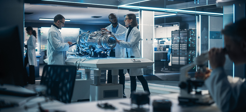 Engineers gathered around a table with a prototype engine.