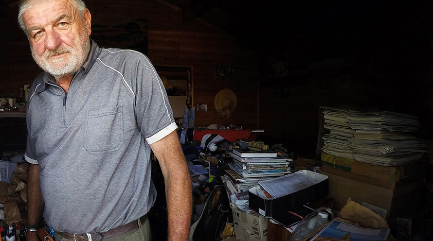 an older man with hoarded stuff in his home