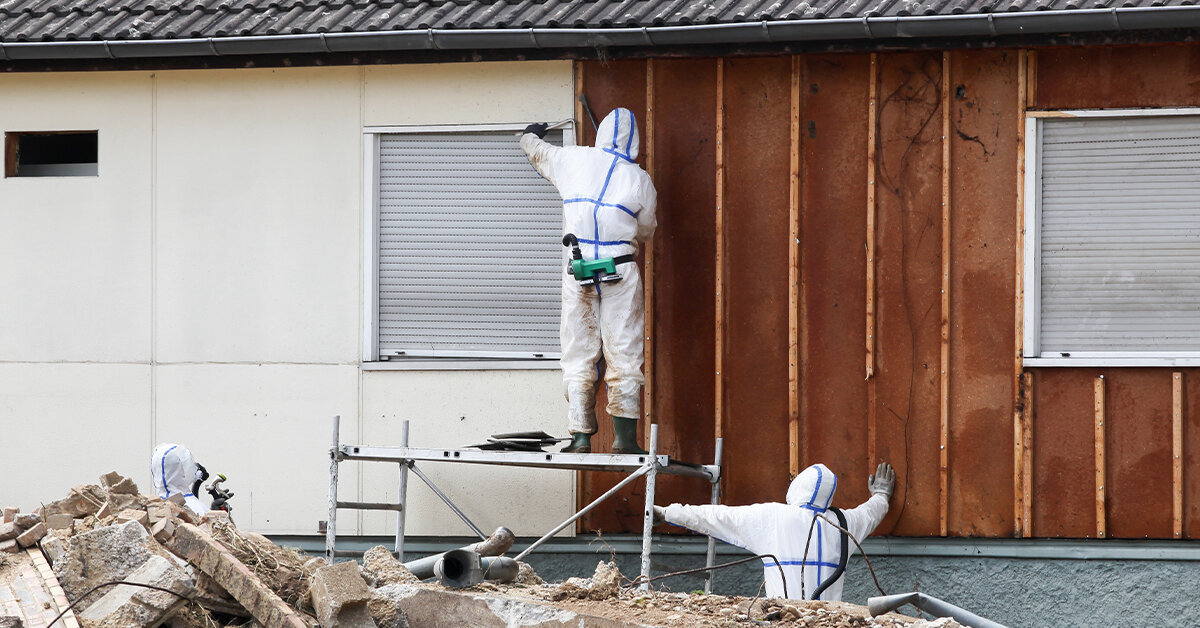 a crew in hazmat suits working on the exterior of a building