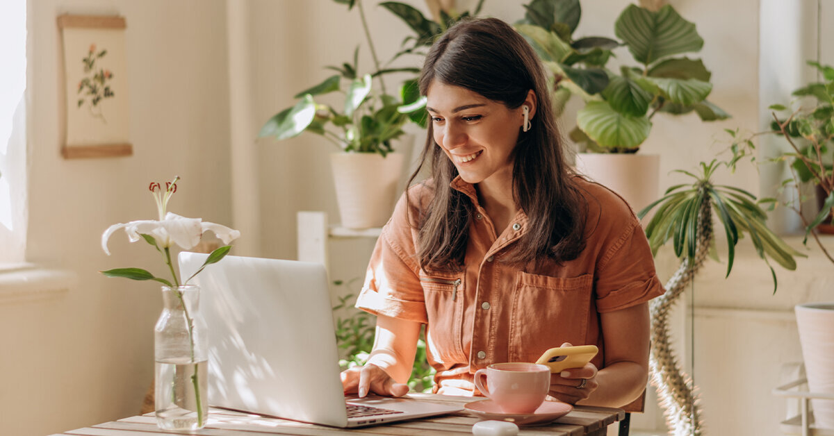 Woman at desk uses laptop