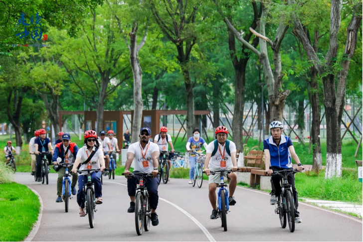 Foreign journalists ride bicycles along the Jinjiang Greenway built by CCCC Southwest Urban Development Co., Ltd.